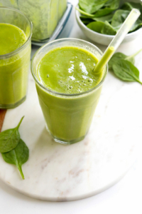green smoothie in glass with straw
