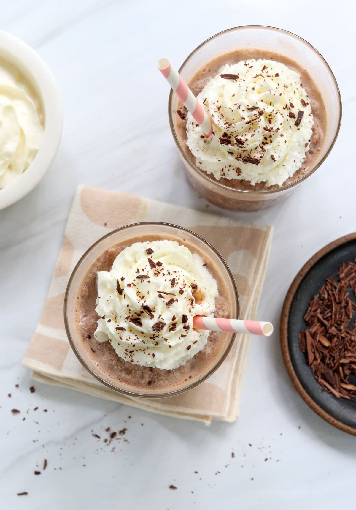 whipped cream added to two glasses.