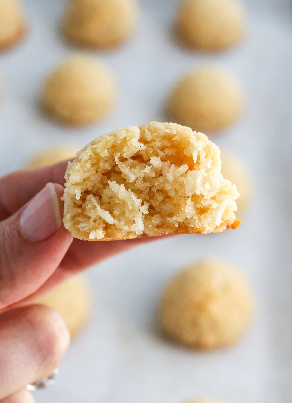 fingers holding a coconut macaroon