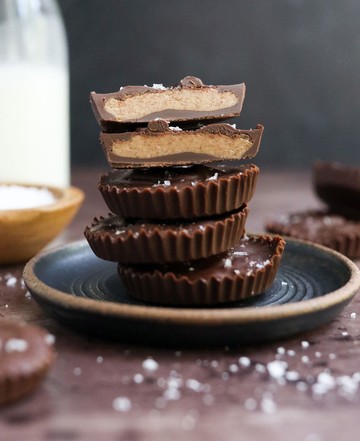 almond butter cups stacked on dark plate.