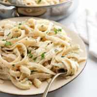 vegan alfredo pasta on plate with fork