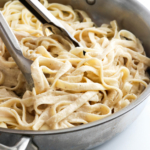 alfredo sauce tossed with pasta in pan