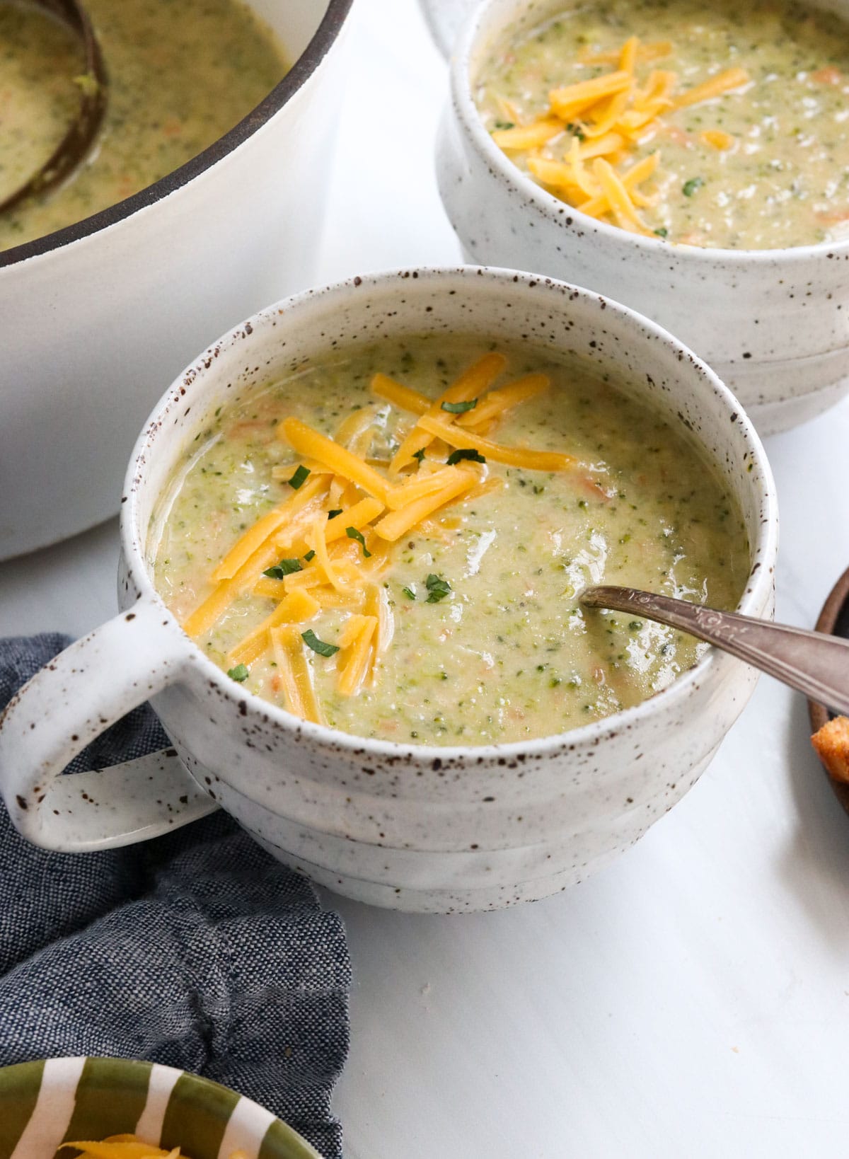 broccoli cheddar soup served with shredded cheese on top.