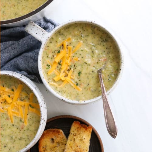 broccoli cheddar soup in a white soup mug.