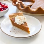 vegan pumpkin pie slice topped with coconut whipped cream