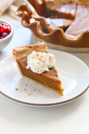 vegan pumpkin pie slice topped with coconut whipped cream