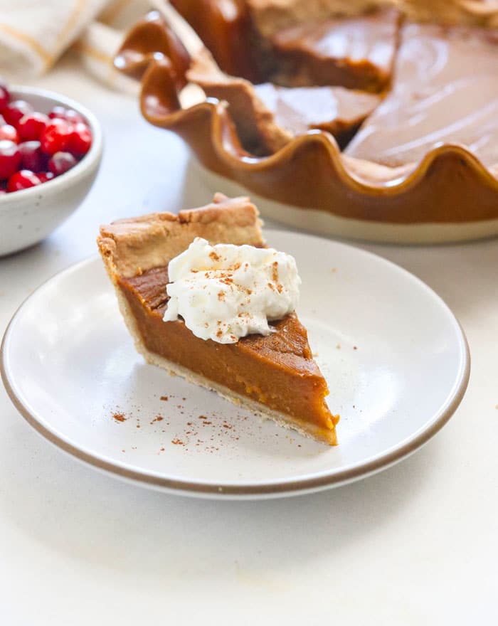 vegan pumpkin pie slice topped with coconut whipped cream