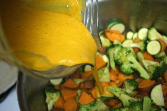pouring sauce over cut veggies 