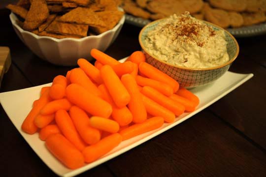 sour cream and carmelized onion dip in a bowl with baby carrots