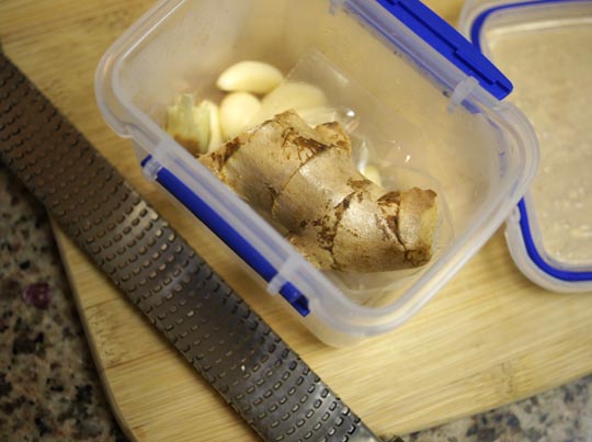 ginger and garlic cloves in a plastic container