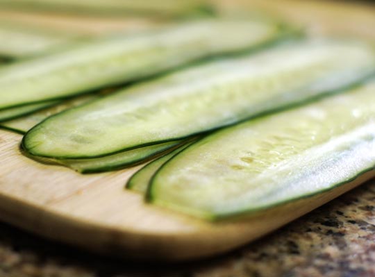 thin cucumber slices on a cutting board