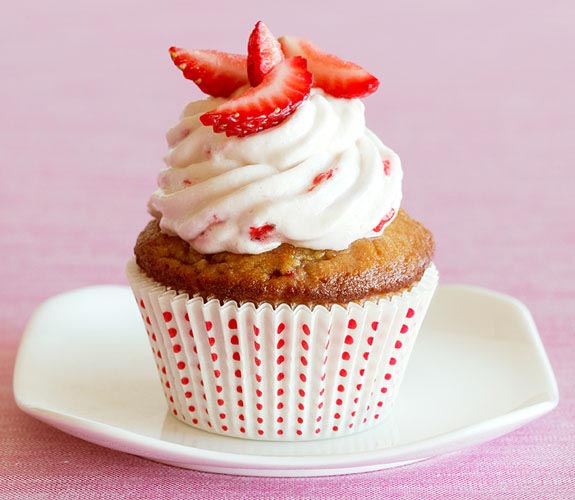 strawberry cupcake with frosting and strawberry slices on top