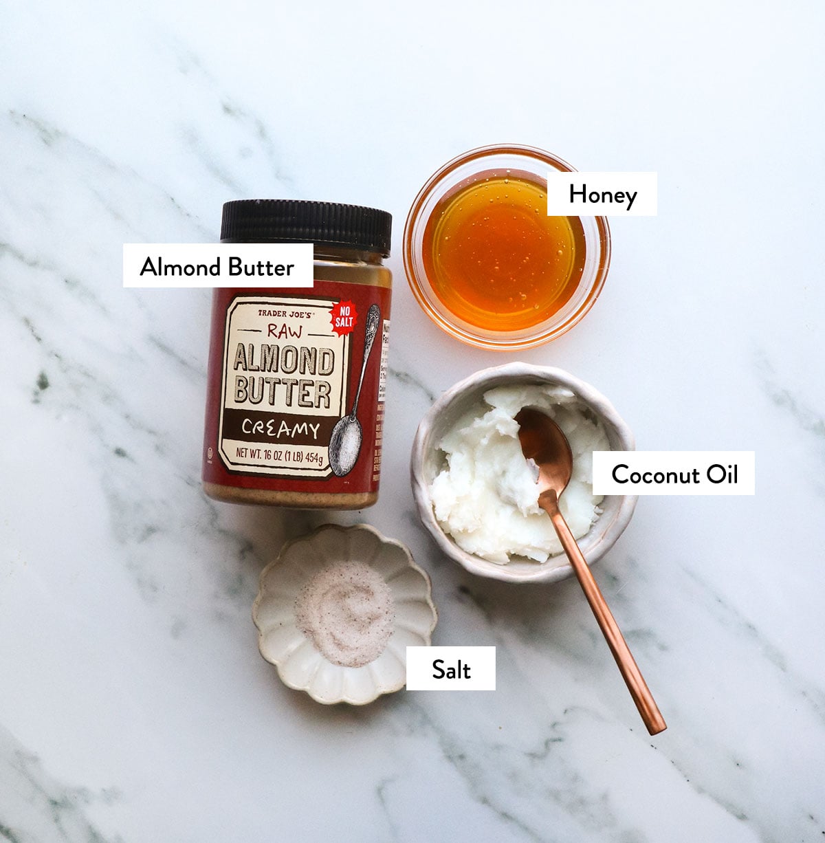 jar of almond butter, coconut oil, honey, and salt labeled on white surface.