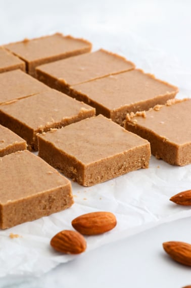 almond butter fudge sliced into squares on parchment paper.