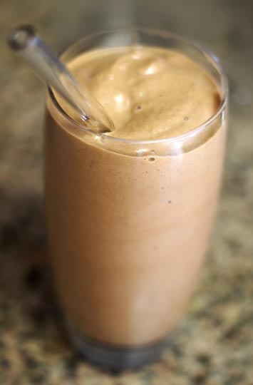 chocolate peanut butter milkshake in a glass with a straw