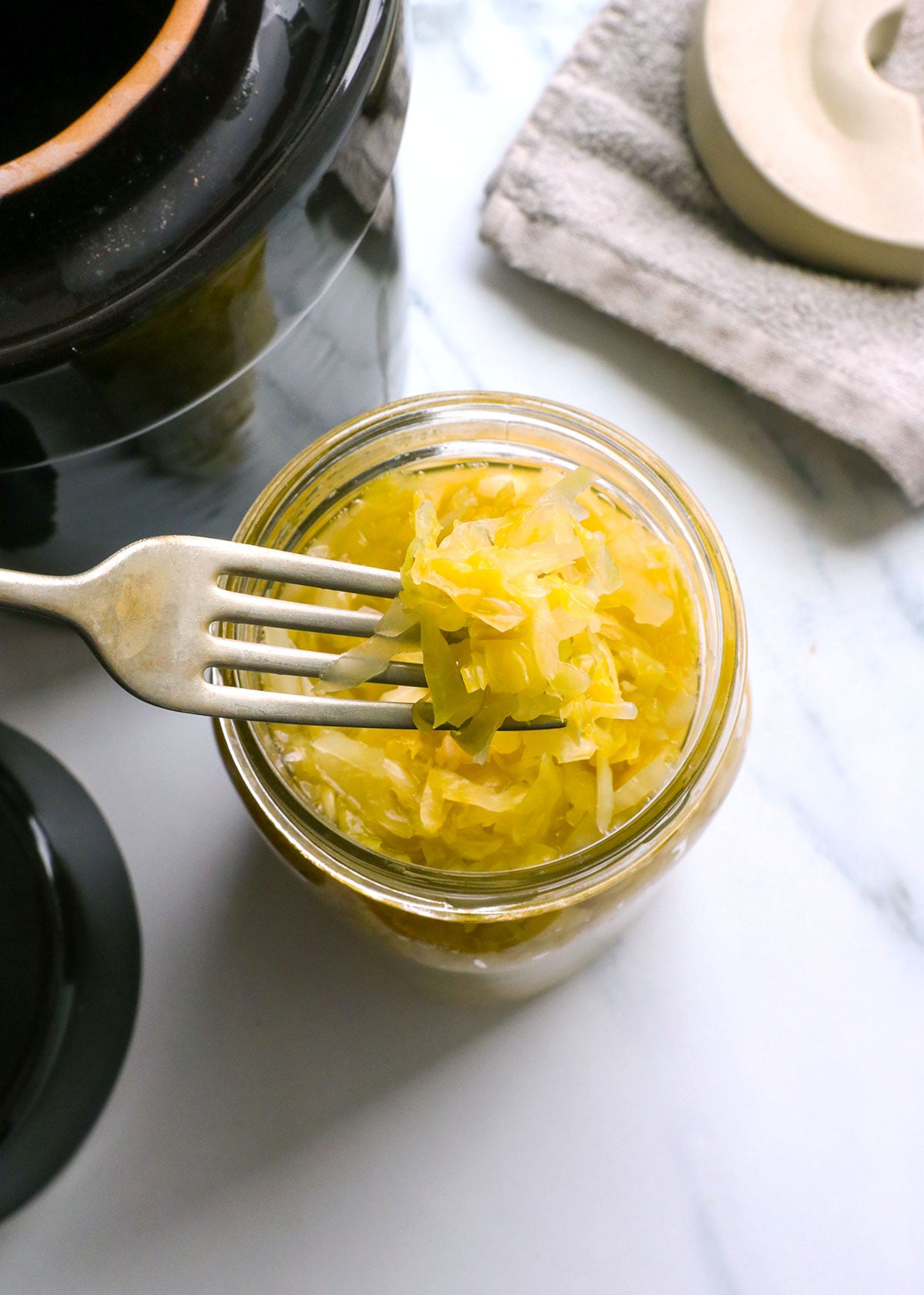 homemade sauerkraut lifted on a fork from a jar.