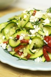 Mediterranean zucchini pasta salad topped with dill and cheese