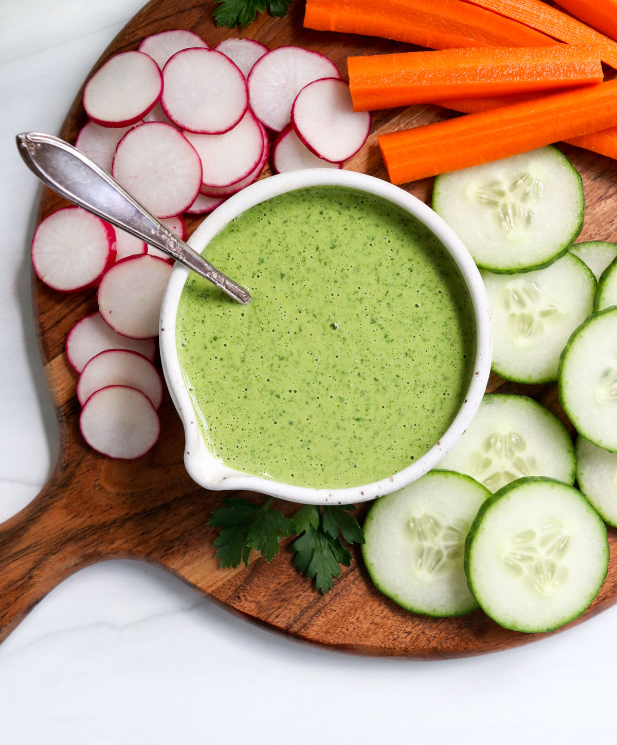 green goddess dressing served on a tray of veggies.