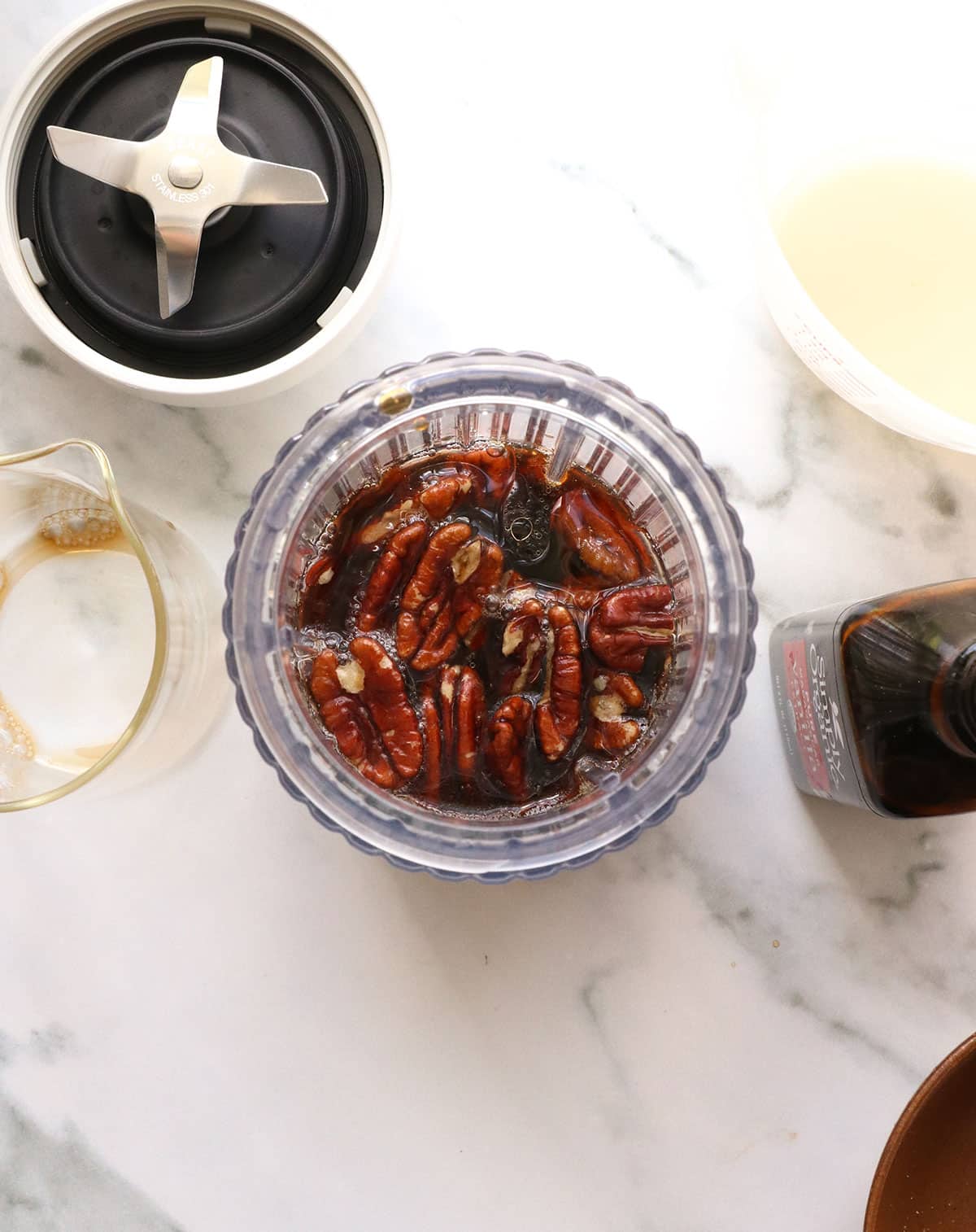 Pecans, maple syrup, and coffee added to a small blender.