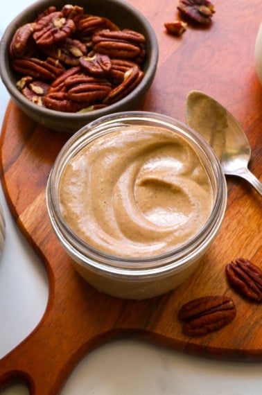 maple pecan glaze swirled in a glass jar on a wooden board.