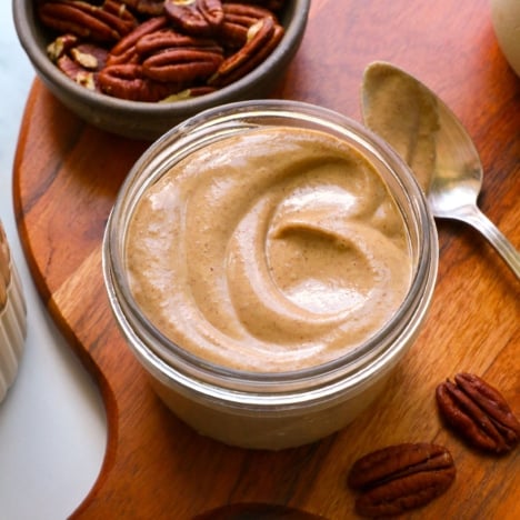 maple pecan glaze swirled in a glass jar on a wooden board.