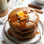 paleo pumpkin pancakes stacked with butter and syrup poured on top