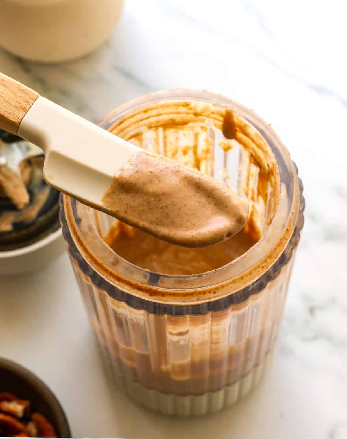 Maple pecan glaze lifted on a spatula for tasting.
