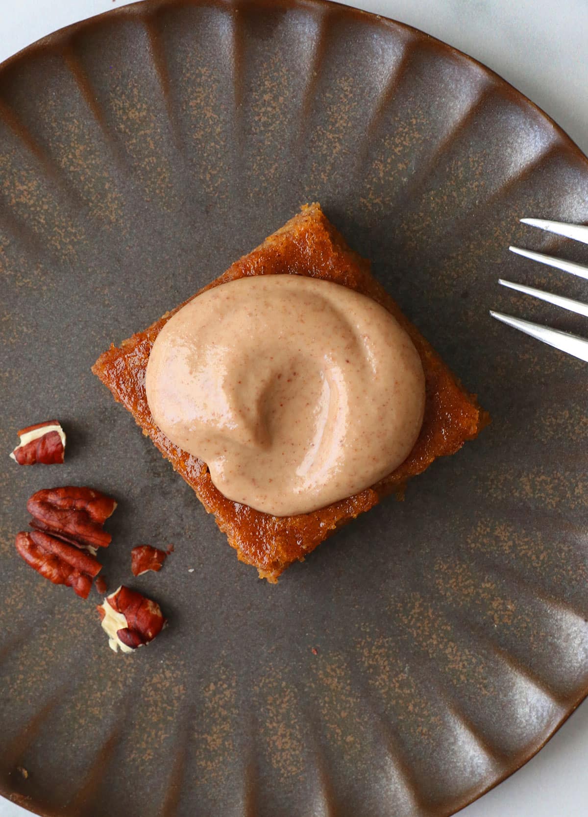 Glaze served on a gluten-free pumpkin bar on a dark plate.
