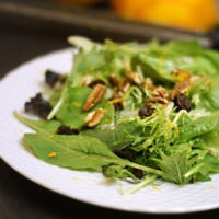 sweet orange vinaigrette on a bed of salad with nuts