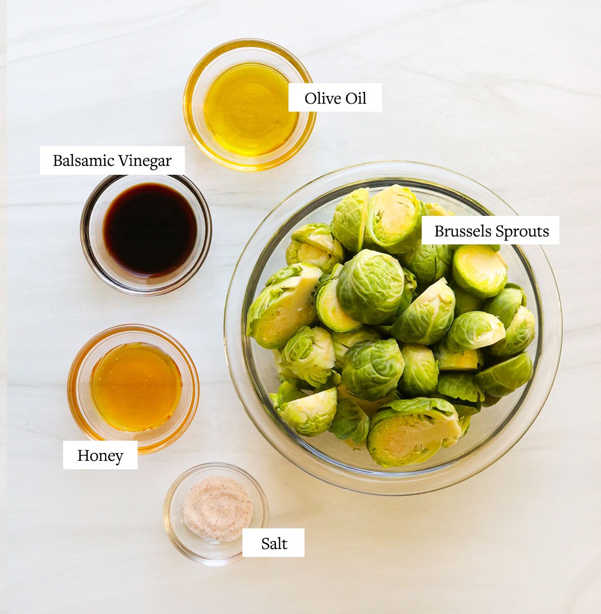 Balsamic brussels sprouts ingredients labeled on a white surface.