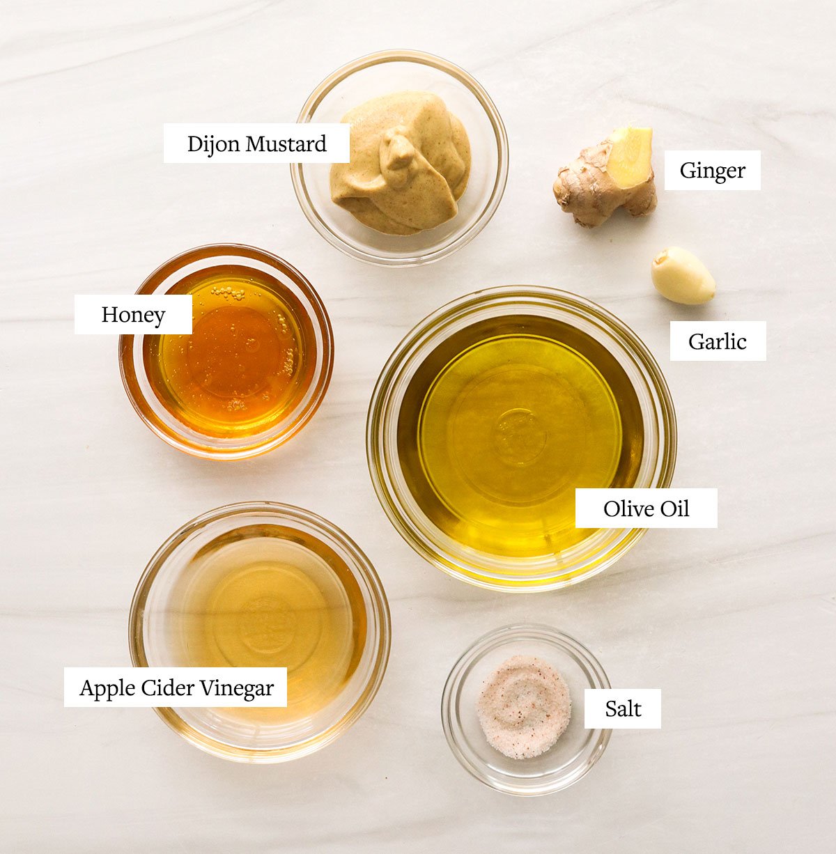 honey dijon dressing ingredients labeled in glass bowls.