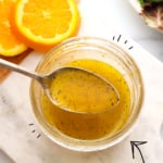 orange vinaigrette on a spoon labeled for Pinterest.