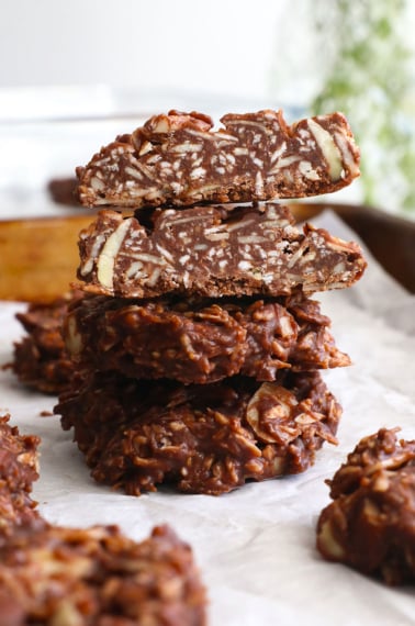 paleo no bake cookies stacked on a pan.