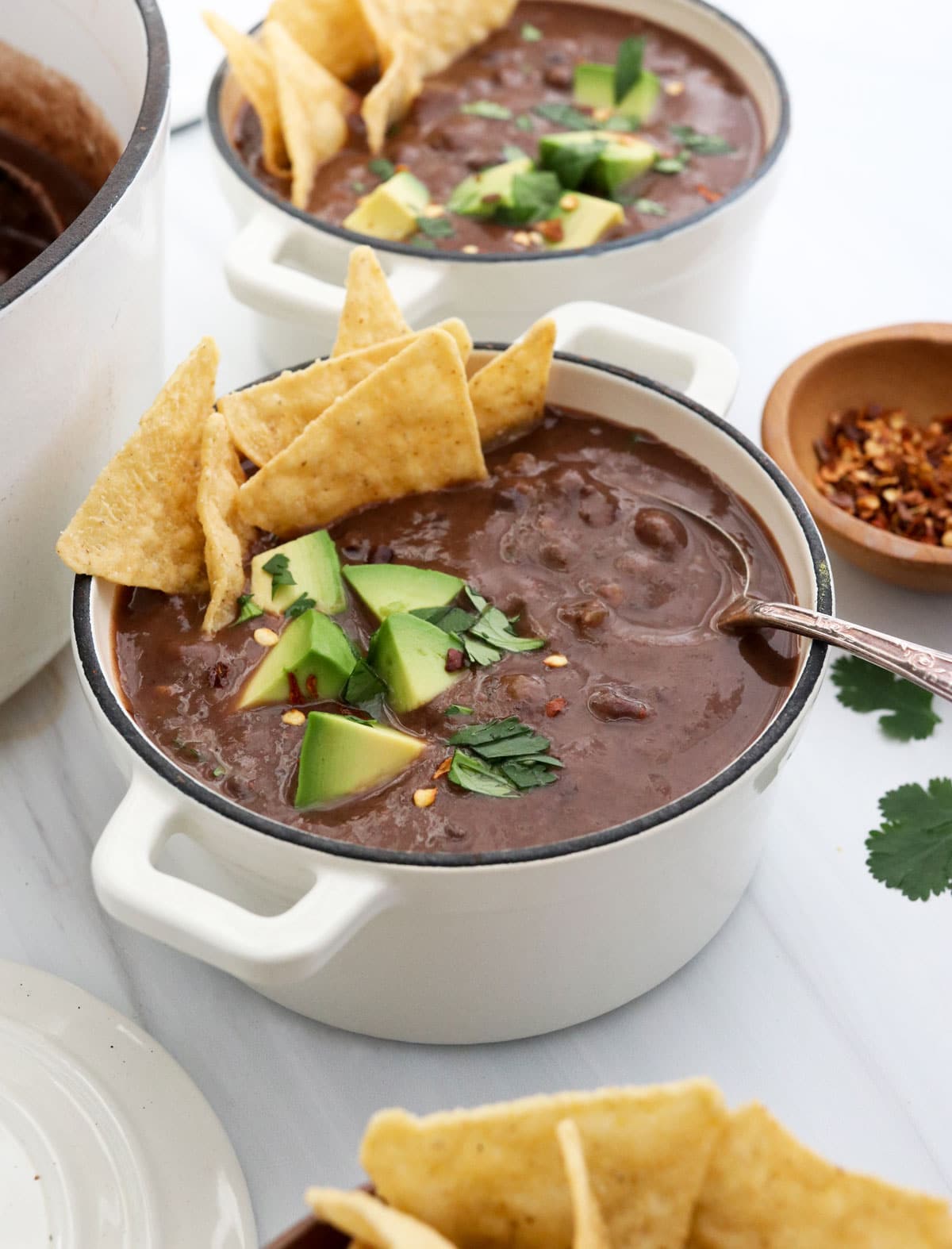 black bean soup in a white bowl at an angle.