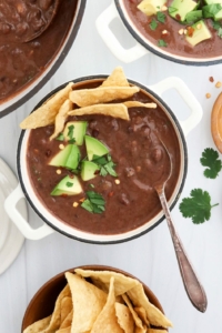 black bean soup with spoon and toppings.