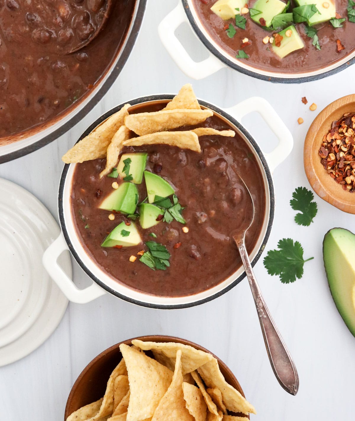 black bean soup with spoon and toppings.