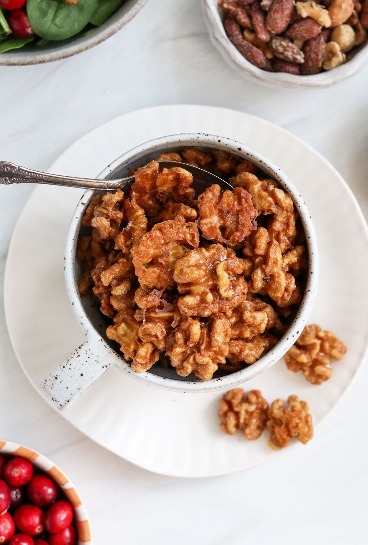 candied walnuts served with a spoon.