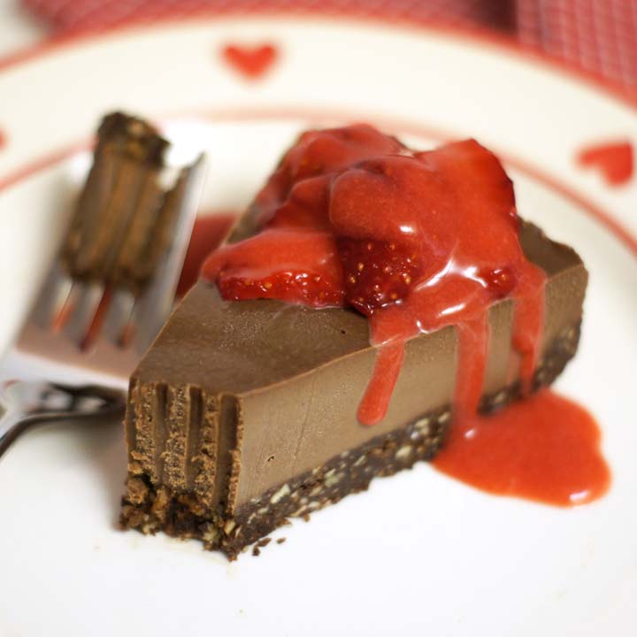 slice of raw chocolate cheesecake with strawberry slices on top
