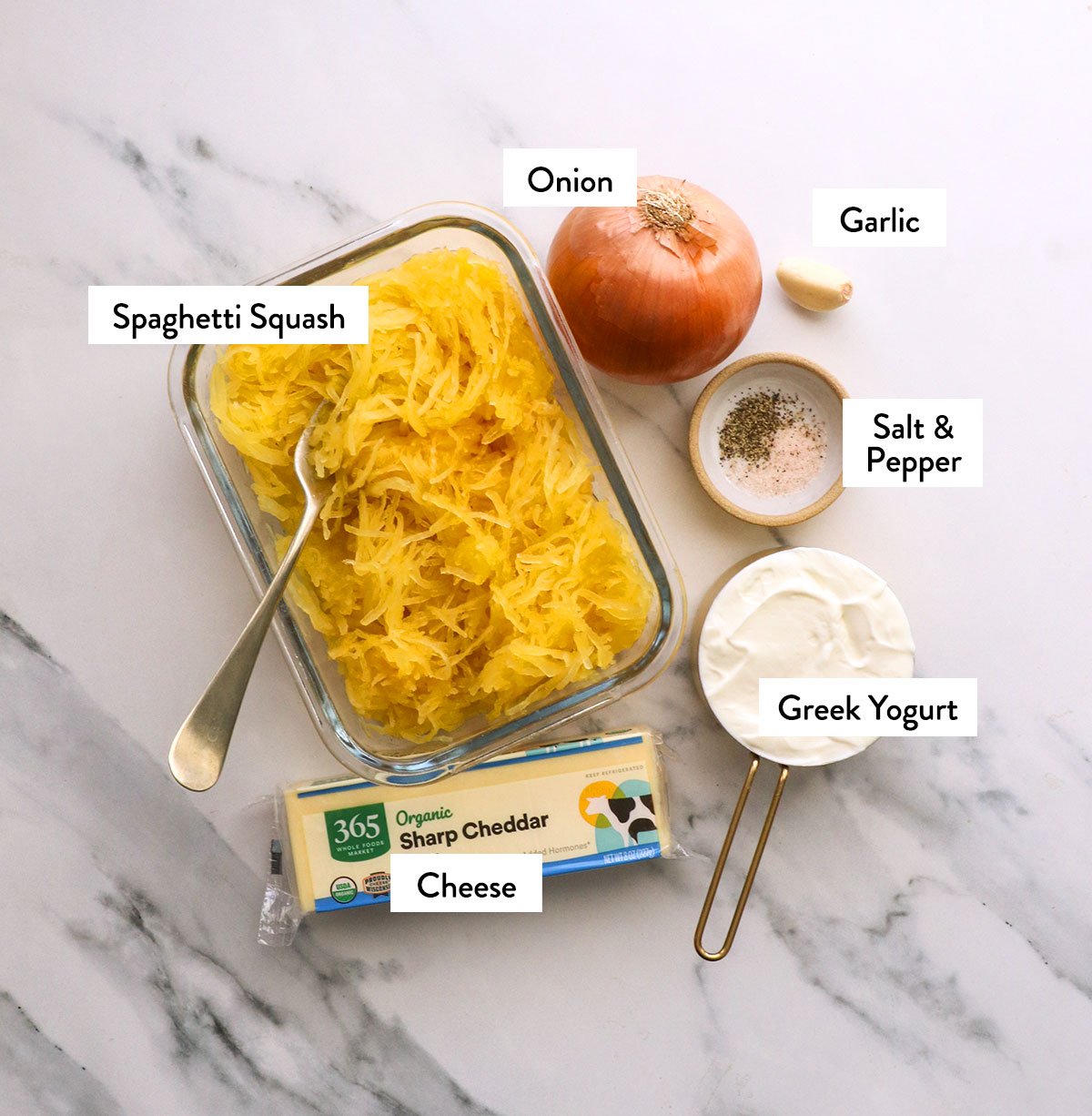 spaghetti squash strands, onion, yogurt, cheese, and spices labeled on a white surface. 