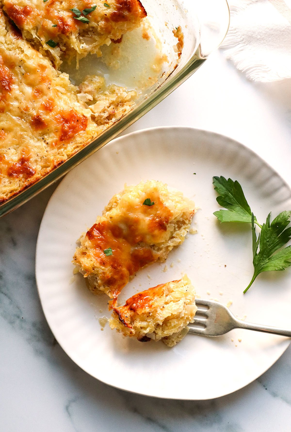 slice of spaghetti squash casserole cut with a fork on a plate. 