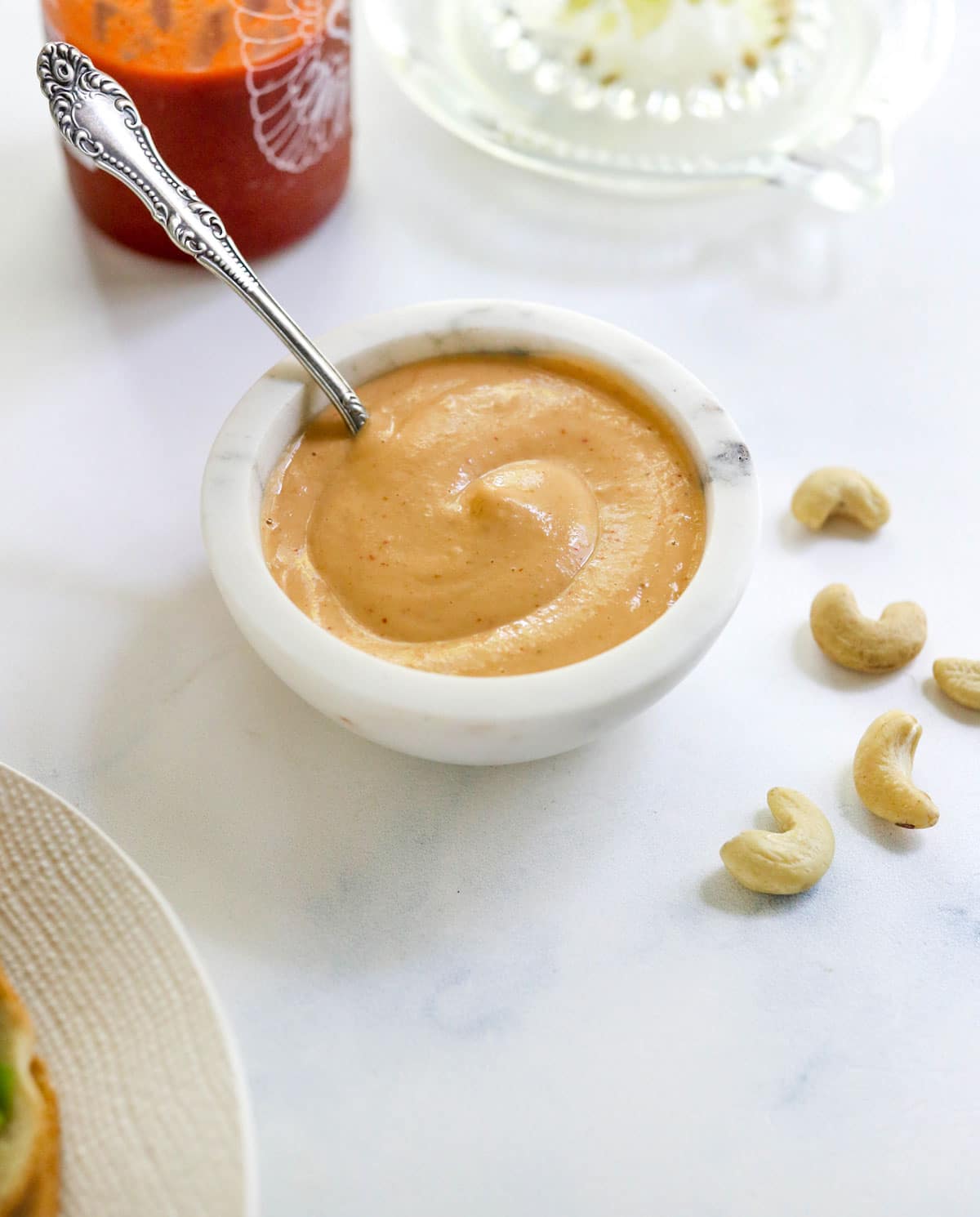 vegan sriracha mayo in a white bowl with spoon