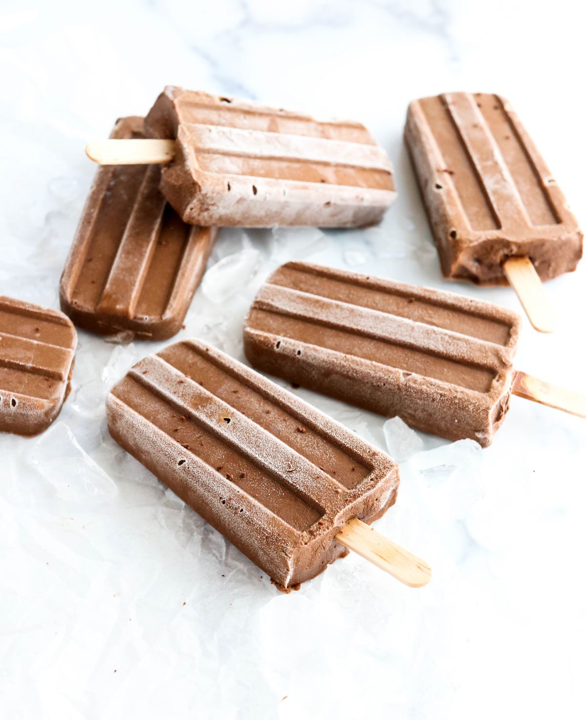 several avocado fudgsicles laying on crushed ice