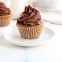 coconut flour cupcakes on white plate with chocolate frosting