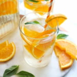 orange infused water with extra orange slices on marble