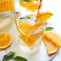 orange infused water with extra orange slices on marble
