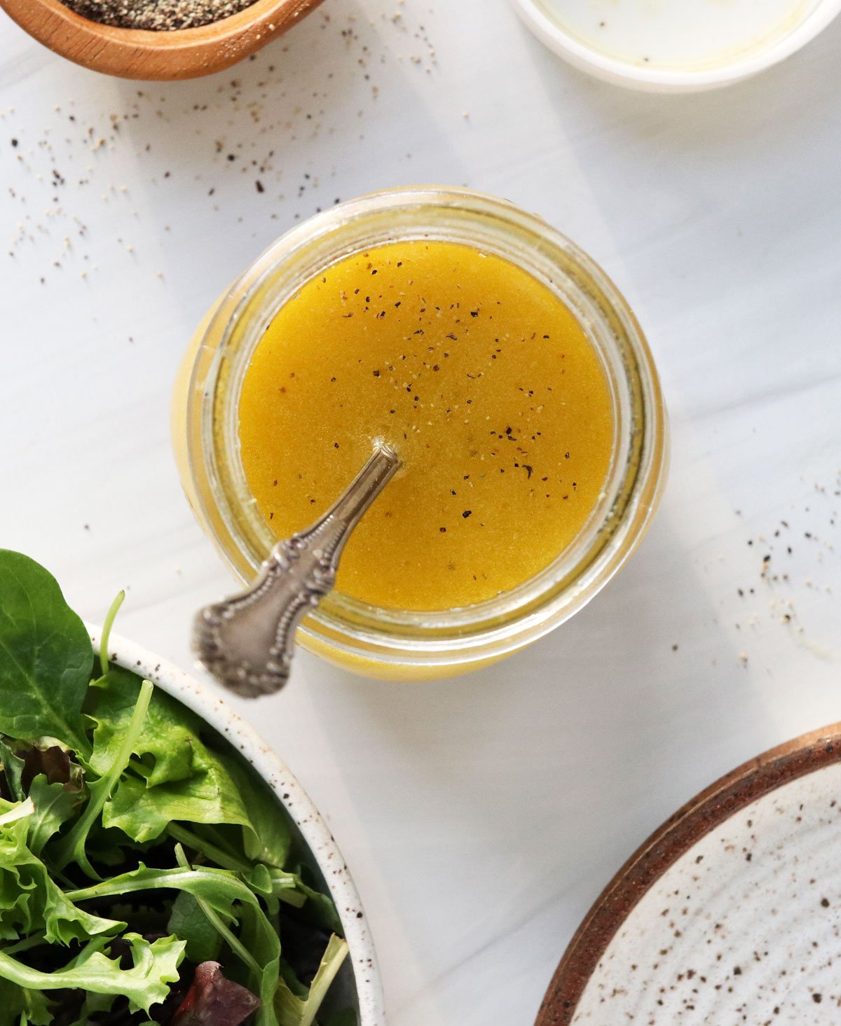 apple cider vinaigrette overhead in glass jar with spoon inside