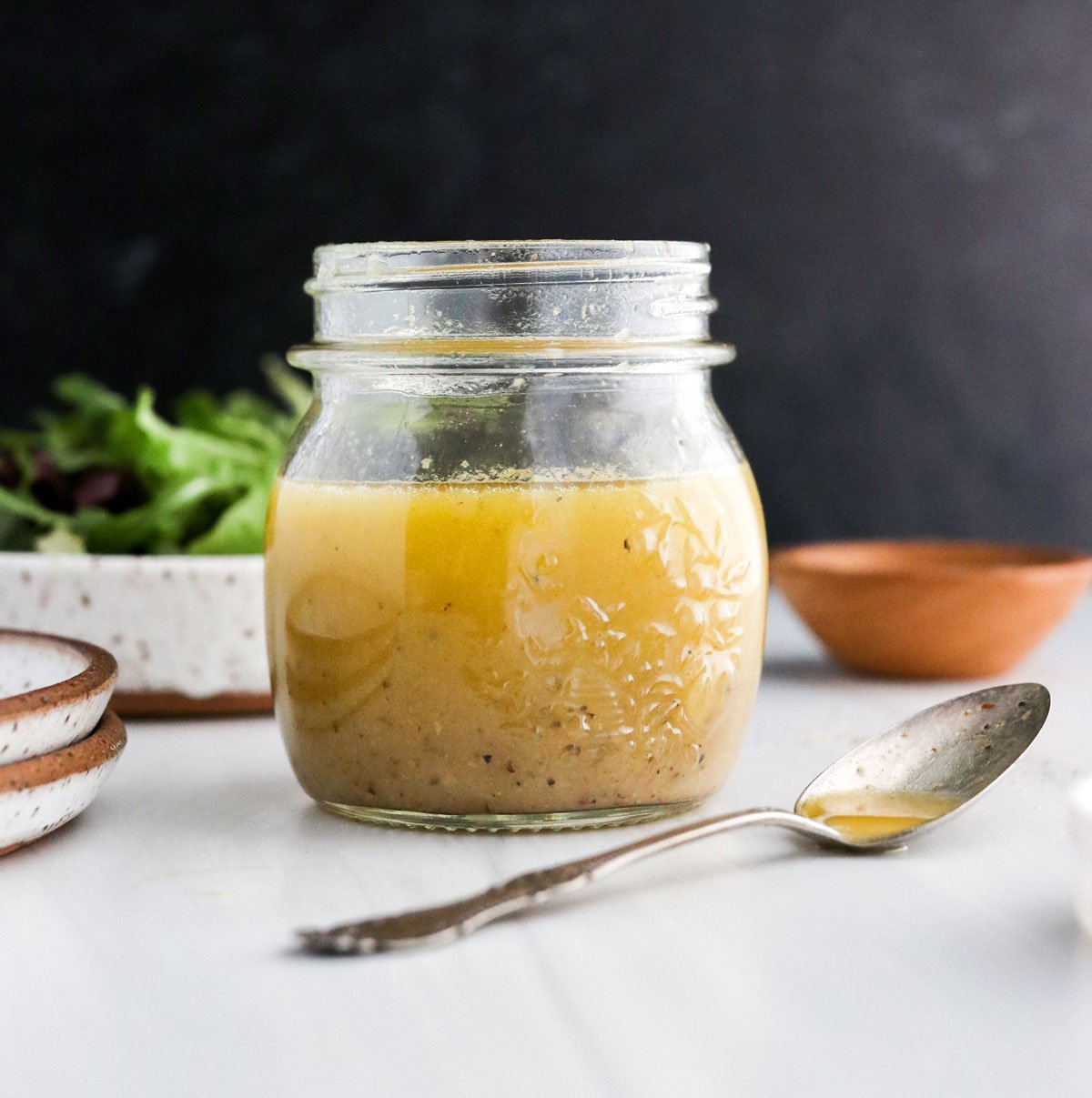 apple cider vinaigrette in glass jar with black background