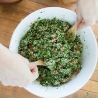 fluffing cauliflower tabbouleh salad with wooden spoons