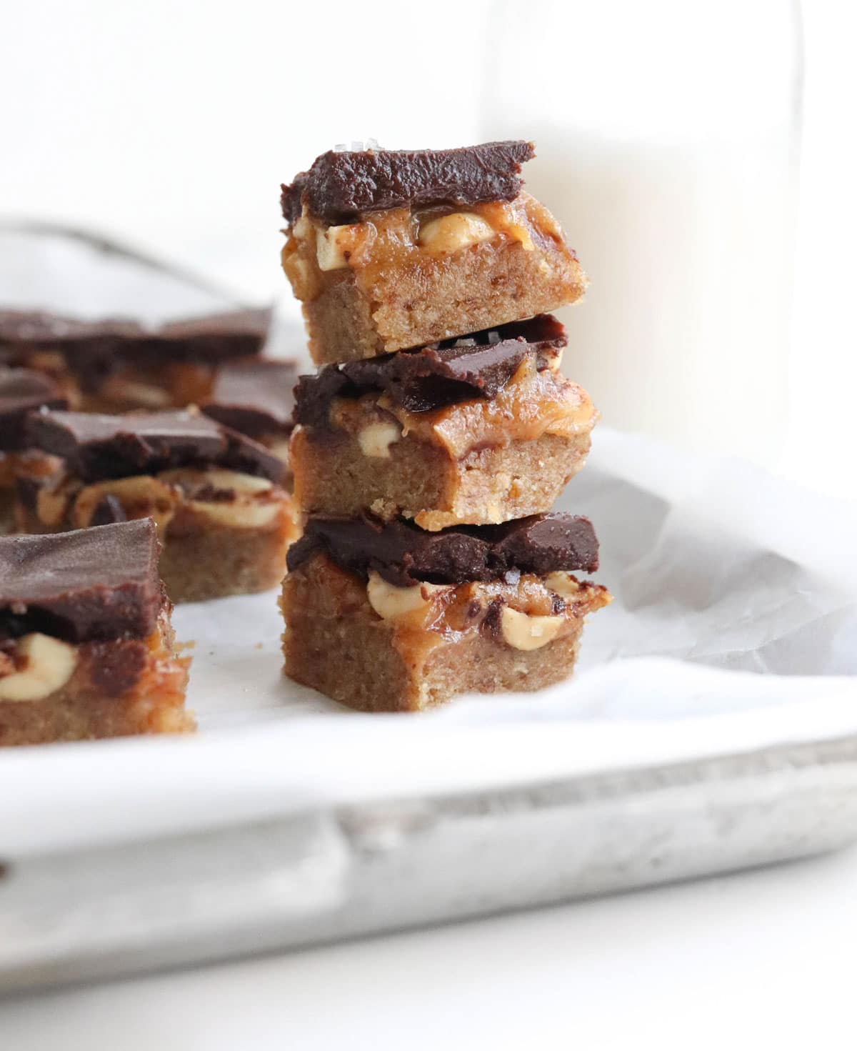 homemade snickers bars stacked on a pan
