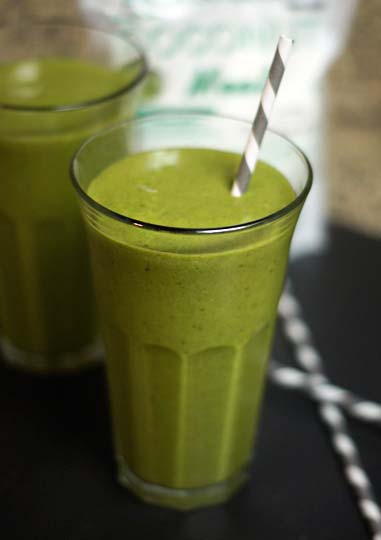 green lactation smoothie in a glass with a straw